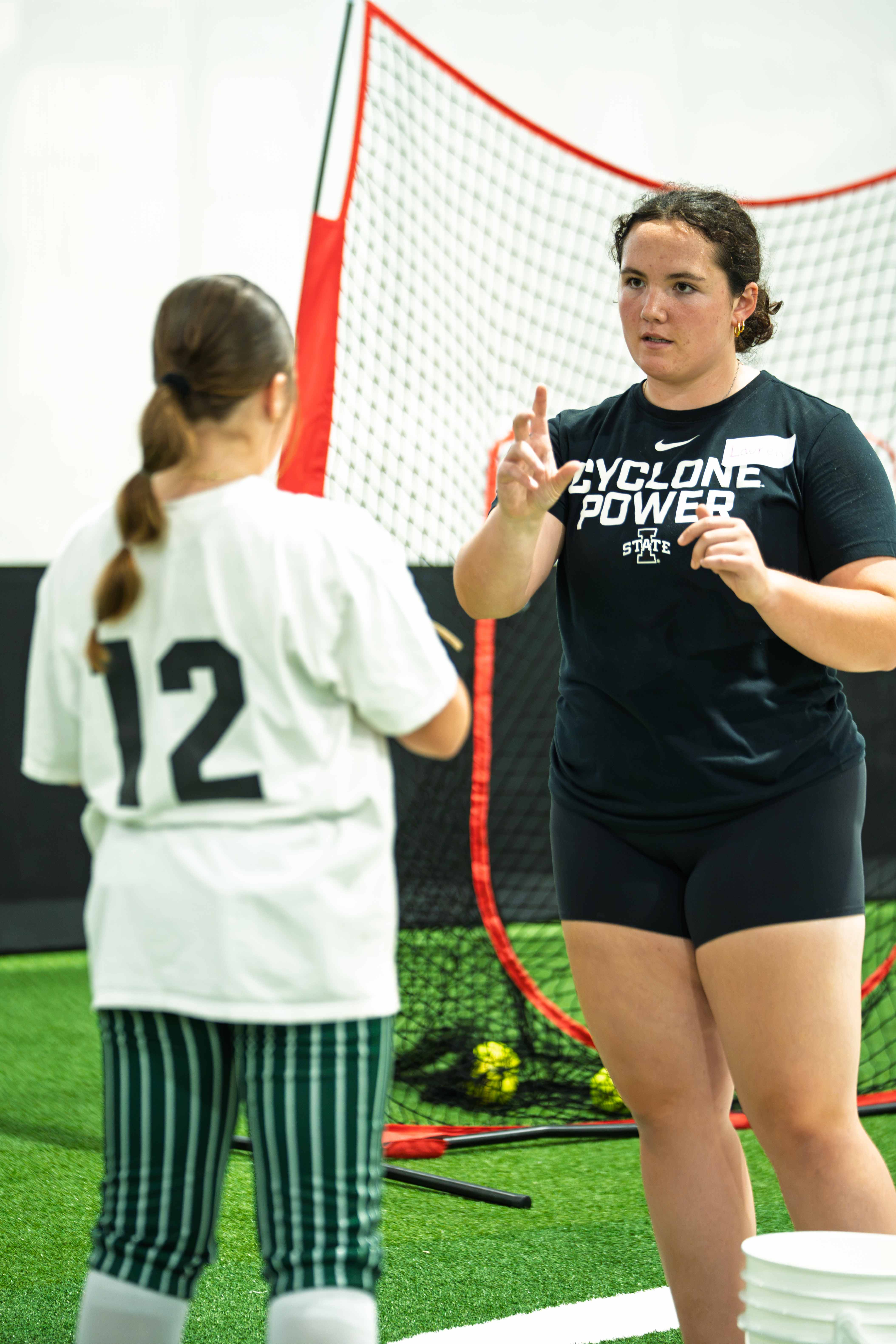 Coach instructing a young player during a drill