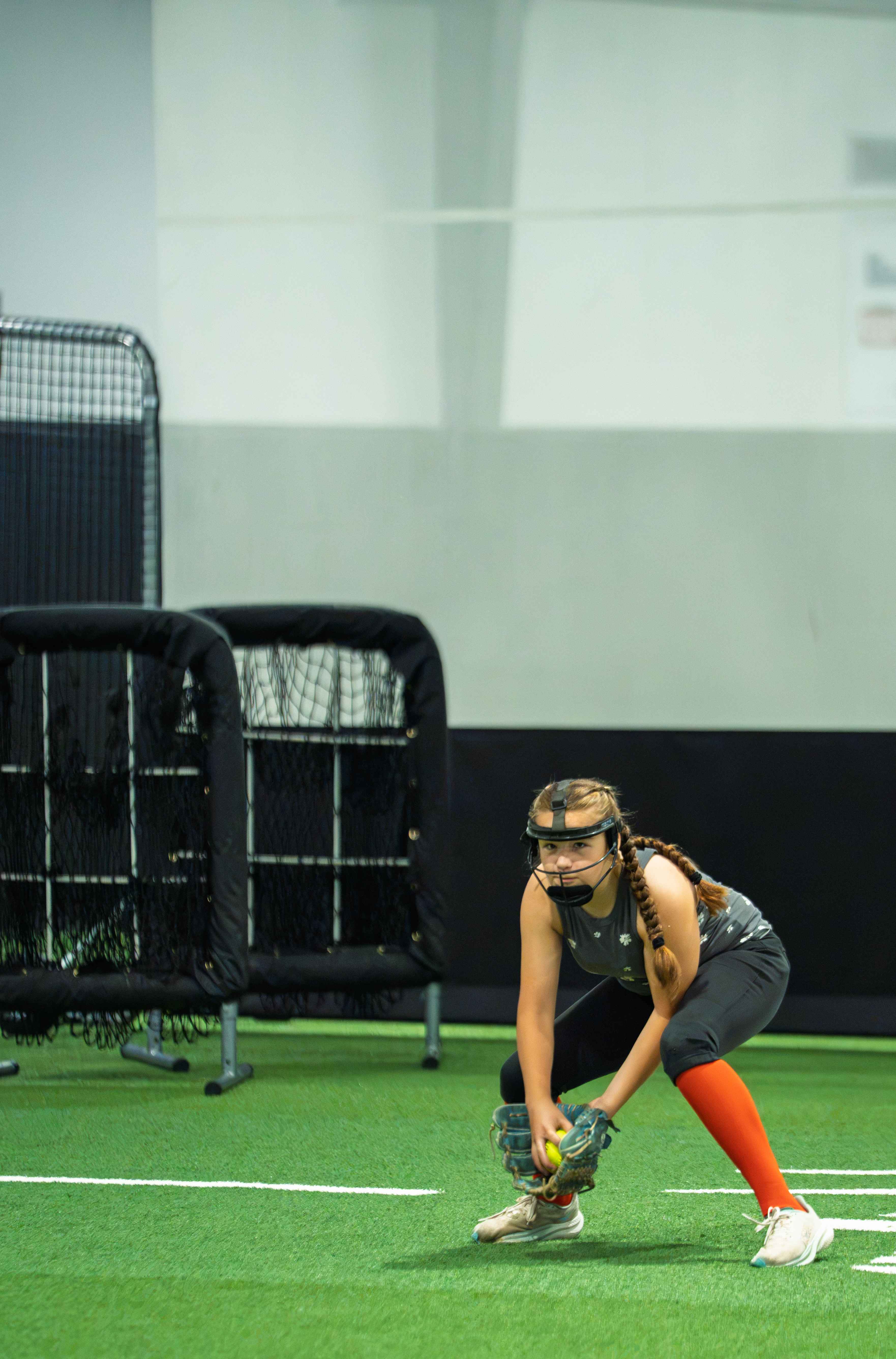 Young fielder in a mask ready to field a ground ball
